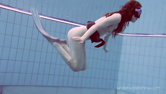 Regardez une superbe rousse nager nue dans une piscine publique