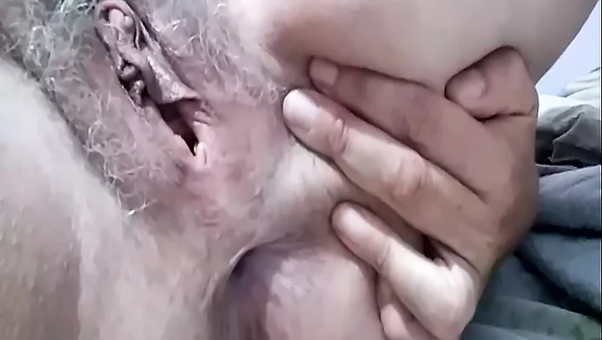 Mature woman with bushy pubic hair exposes her wet and hairy vagina